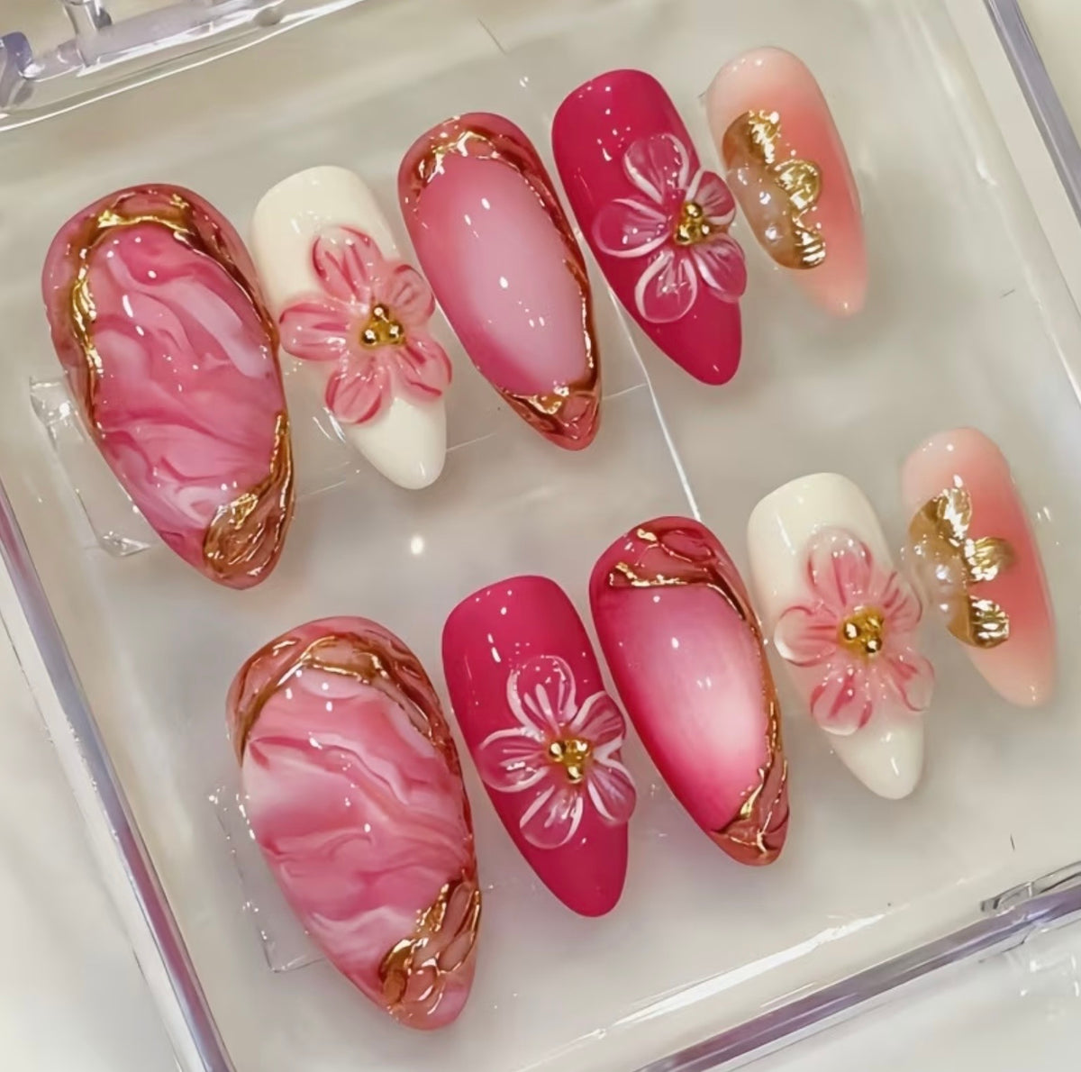 Side view of almond press-on nails set in clear box – pink ombré, 3D flowers and gold details – Lande Accessories